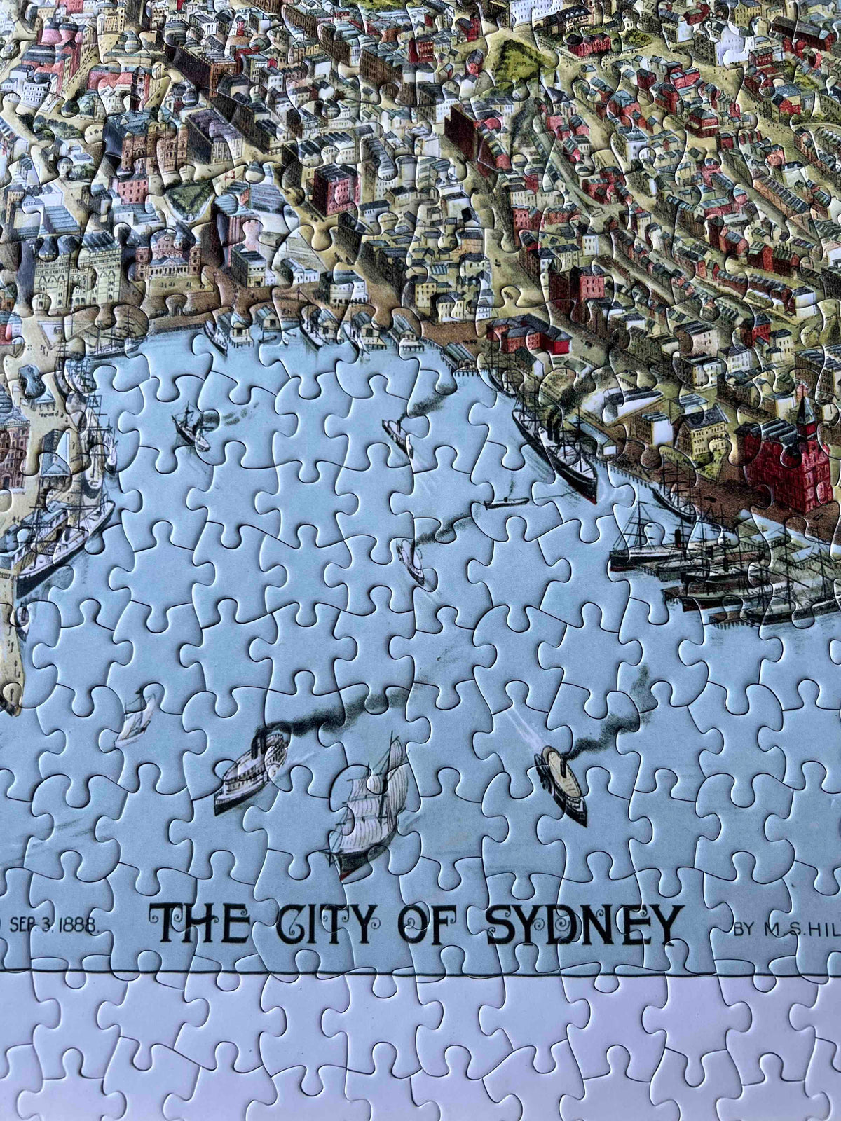 A small area of a made up jigsaw puzzle with the words The City Of Sydney in the picture