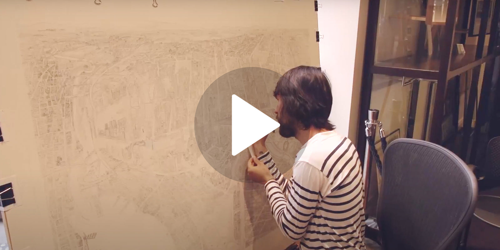 Lewis Brownlie working on the line drawing of The Melbourne Map work in progress at an exhibition in 2017