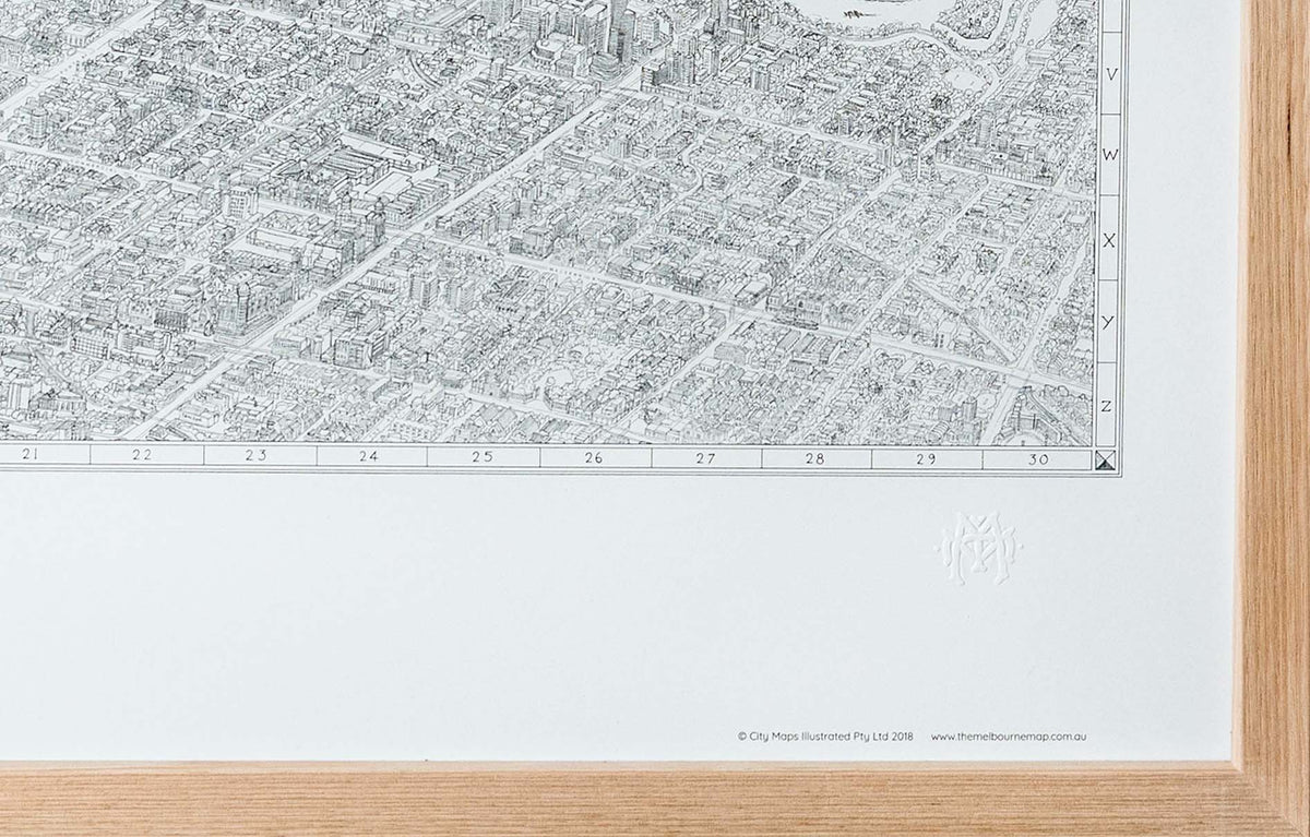A close-up of the bottom right corner of the black and white line drawing of The Melbourne Map showing the intricate details of the illustration as well as the embossing. Framed in oak