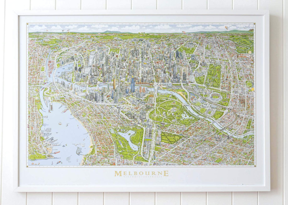 A large version of the colour Melbourne Map in a white frame hanging on a white panelled wall in a bright airy room 