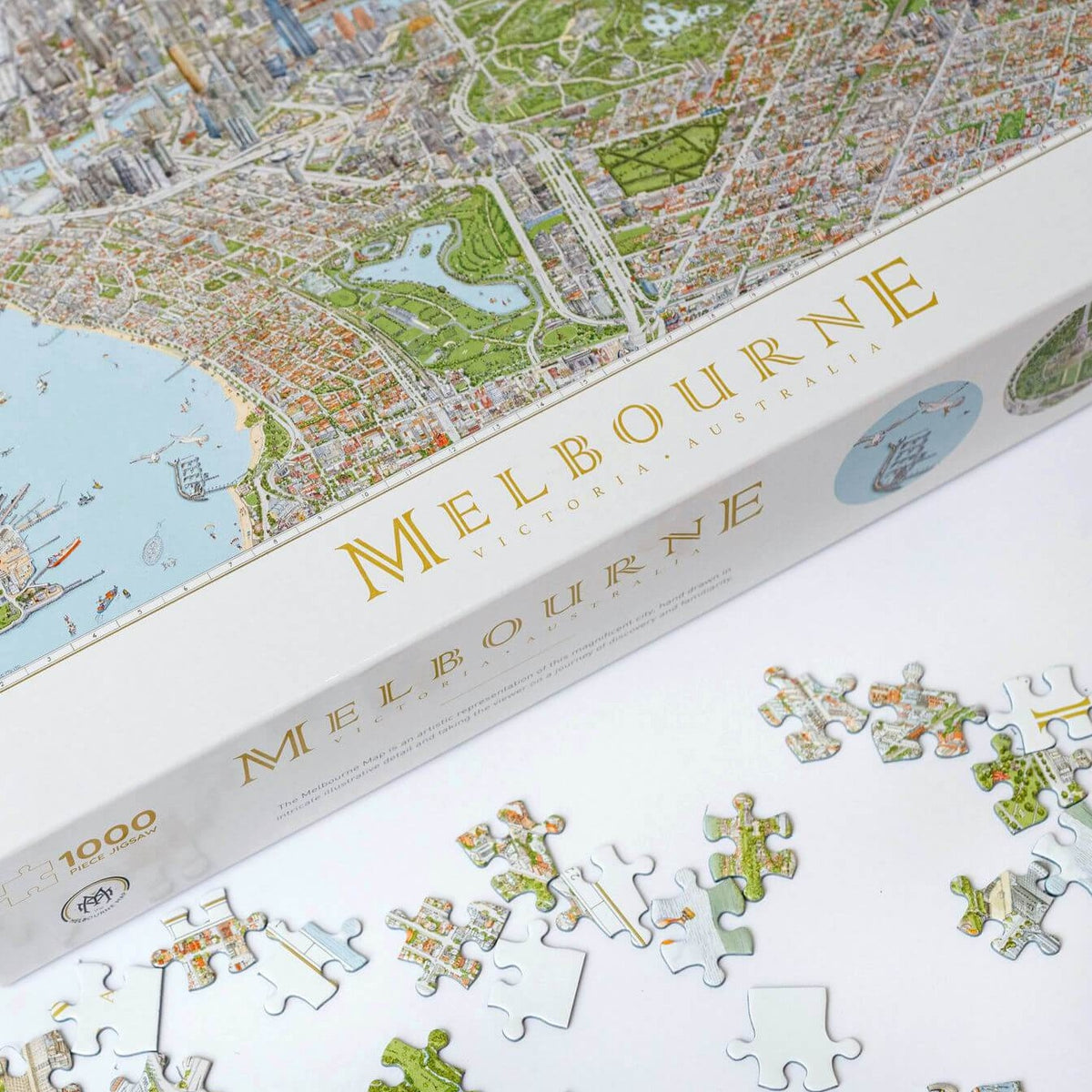 The Melbourne Map 1,000-piece jigsaw puzzle on a white table showing the bottom left corner of the box and some loose pieces