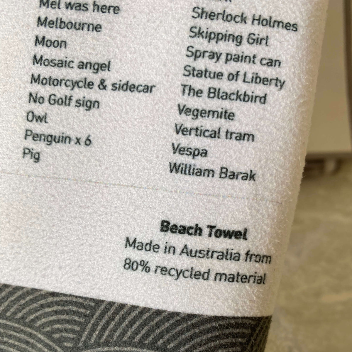 Close-up shot of The Melbourne Map Beach Towel bag showing some of the items to find on the map and text which says &quot;Made in Australia from 80% recycled material.&quot; 