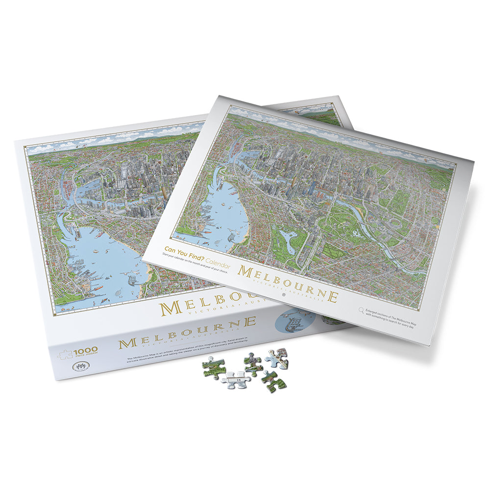 The Melbourne Map "Can You Find?" Calendar sitting on top of the box of the 1,000-piece Melbourne Map jigsaw puzzle box on a white background. There are 4 loose pieces sitting in front of the box. 