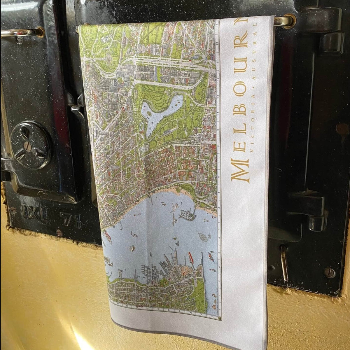 A closer shot of The Melbourne Map Tea Towel hanging over the handle of Mel&#39;s mum&#39;s antique wood burning oven 